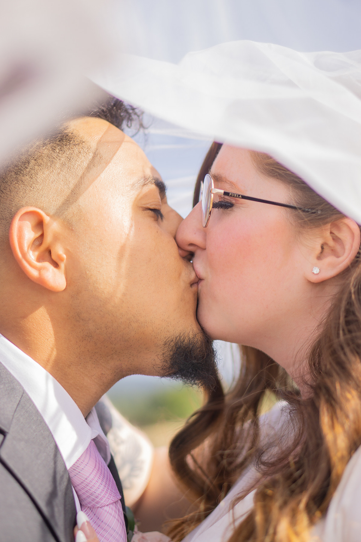 Bride and groom sharing a kiss under the veil